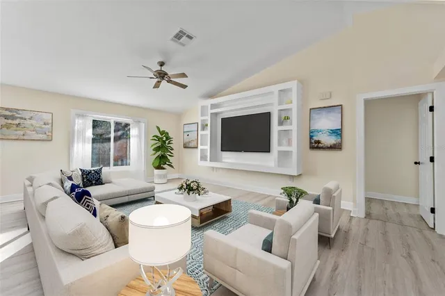 a living room with furniture a flat screen tv and a window