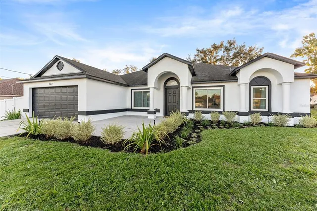 a front view of a house with a garden