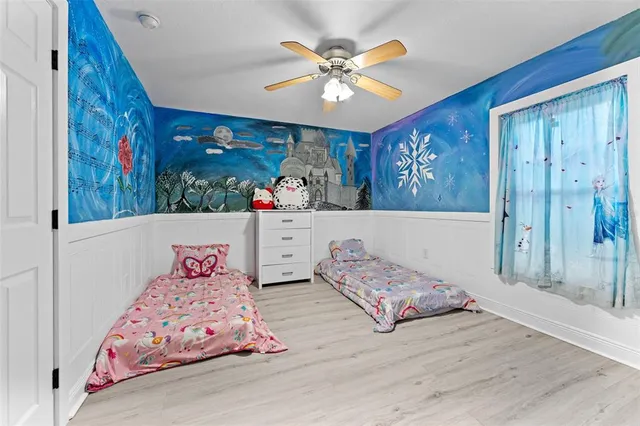 a bedroom with two beds and a painting on the wall