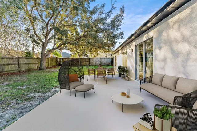 a view of a patio with couches table and chairs and potted plants