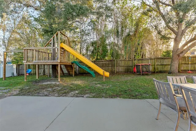 a view of a house with a backyard and a slide