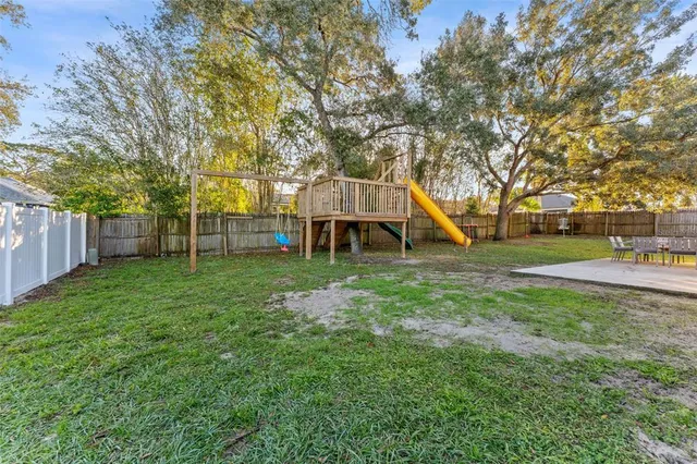 a view of a house with backyard and a tree