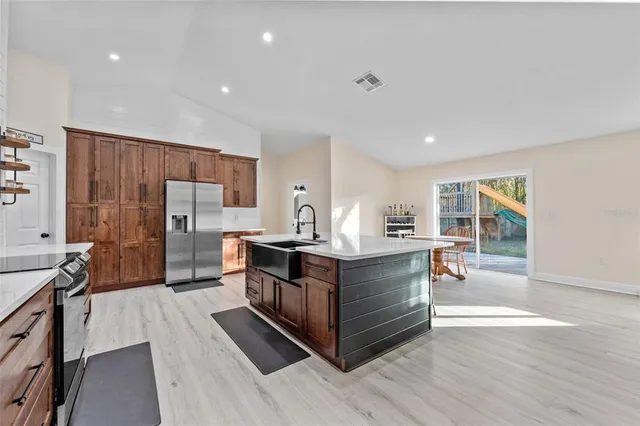 a kitchen with stainless steel appliances granite countertop a lot of counter space and wooden floors