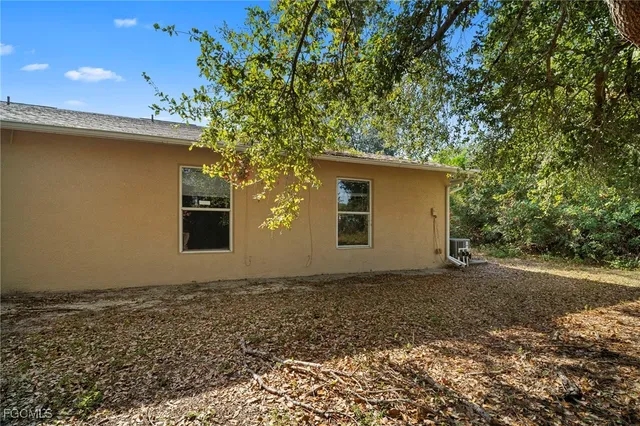 a view of a house with backyard and trees