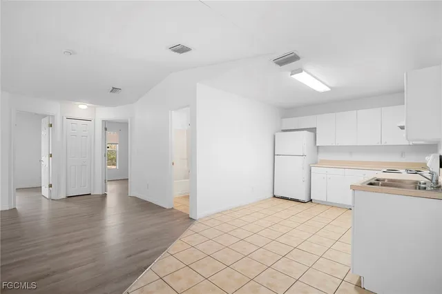 a kitchen that has a sink and white cabinets