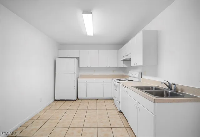 a kitchen with white cabinets and white appliances