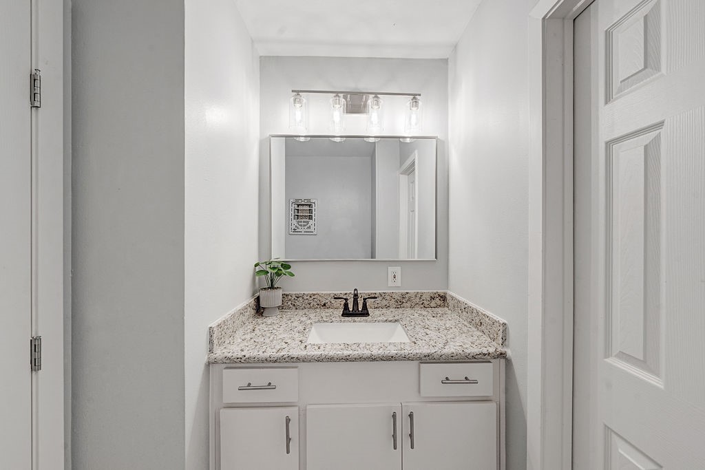 614 Gilpin Street Houston, TX 77034 - Photo 14 of 27 Experience effortless living with this conveniently located bathroom just off the living room, featuring elegant granite countertops and sleek cabinetry.