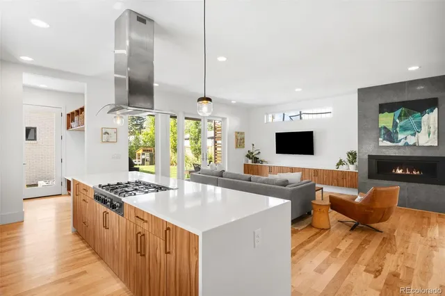 a kitchen with stainless steel appliances granite countertop a sink a stove and a wooden floors