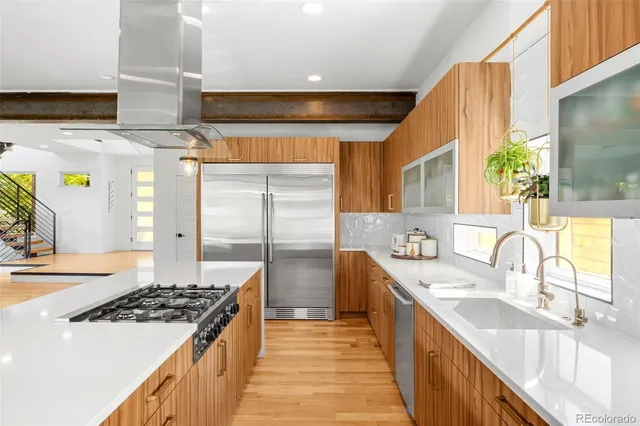 a kitchen with stainless steel appliances a sink stove and cabinets