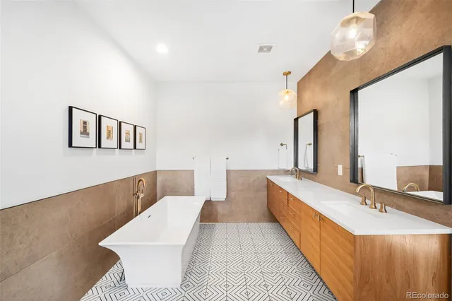 a bathroom with a double vanity sink a mirror and a bathtub