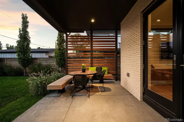 a backyard of a house with a table and chairs