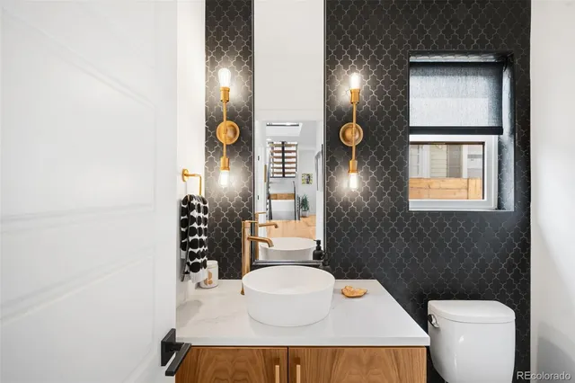 a bathroom with a sink a toilet and mirror