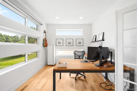 a spacious bedroom with a bed a couch and a large window