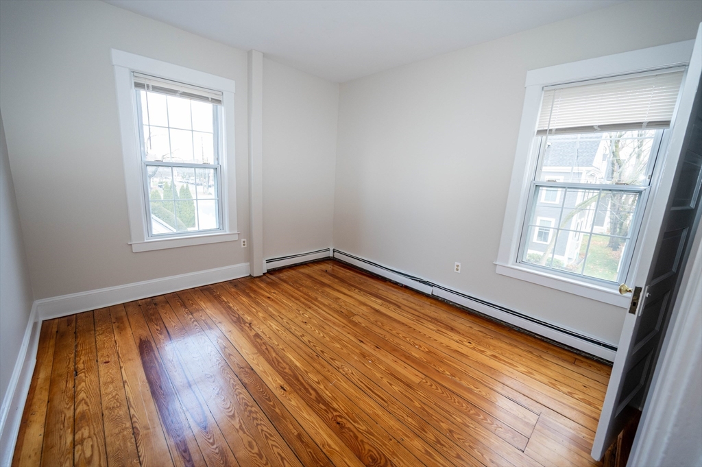 5 Colchester Street, Unit 2 Boston, MA 02136 - Photo 14 of 19 an empty room with wooden floor and windows