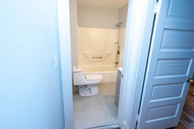 a bathroom with a granite countertop toilet and a sink