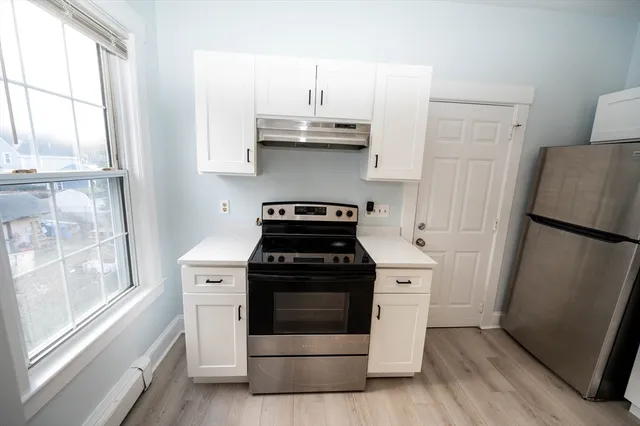 a white stove top oven sitting inside of a kitchen