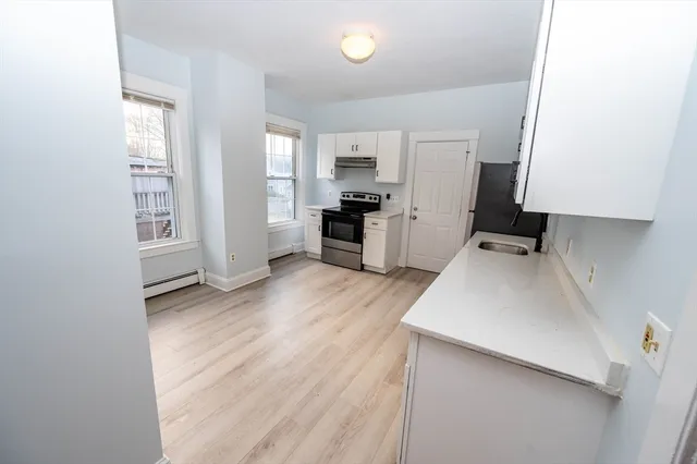 a kitchen with a refrigerator and a stove top oven