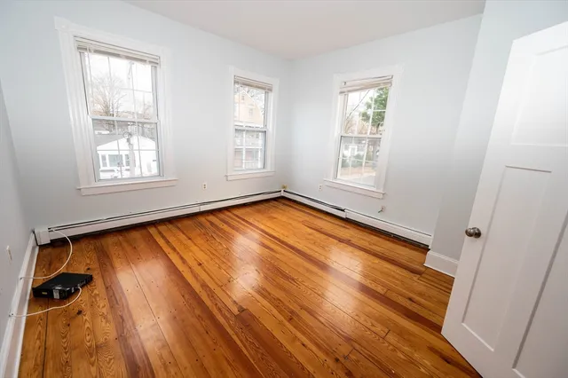a view of a room with wooden floor and window