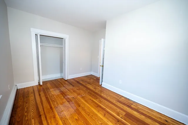 a view of a room with wooden floor and closet