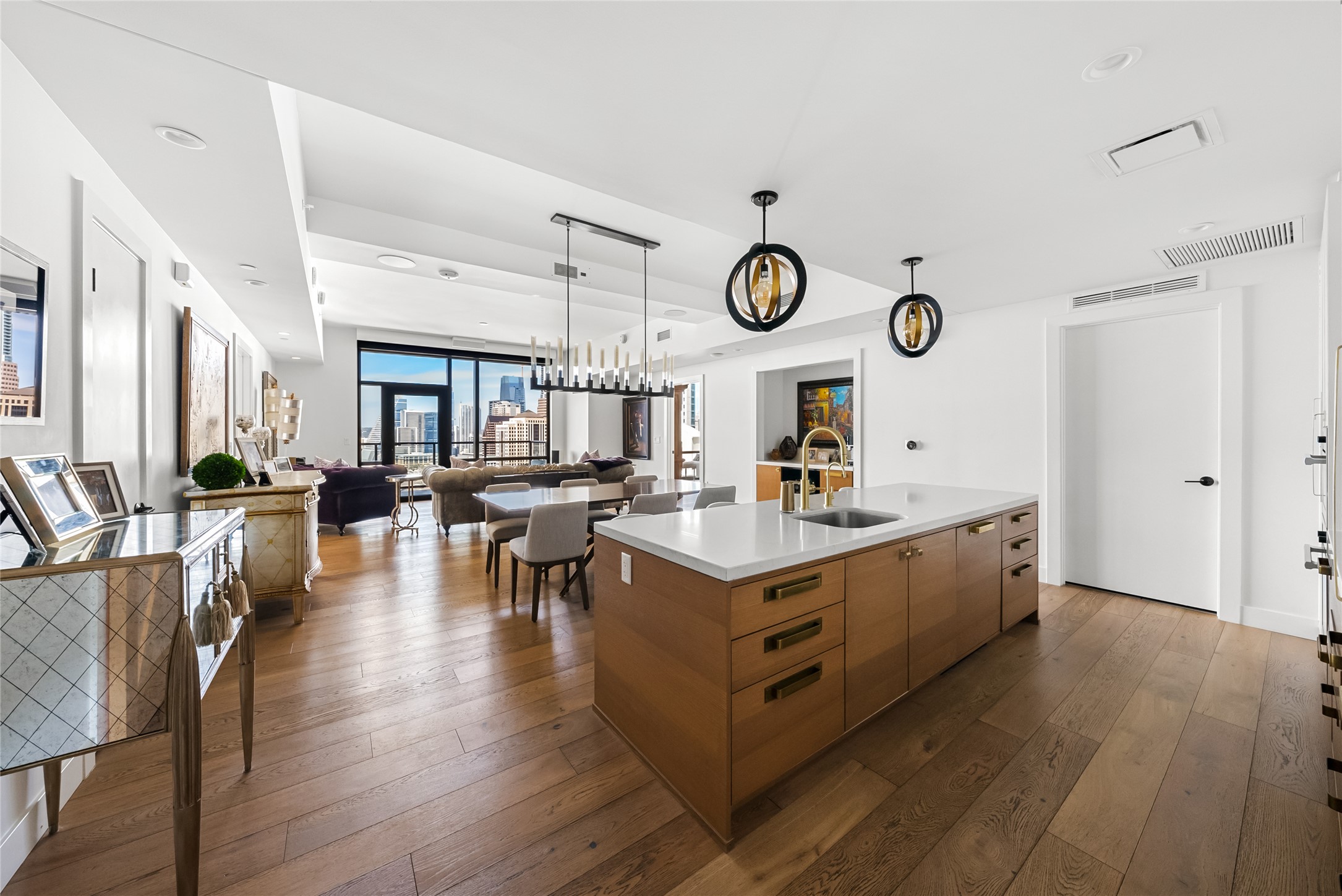 70 Rainey Street, Unit 2106 Austin, TX 78701 - Photo 27 of 28 Kitchen featuring dark wood finished floors, hanging light fixtures, open floor plan, an island with sink, and modern cabinets