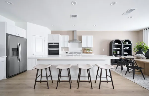 a kitchen with stainless steel appliances a table chairs and a refrigerator