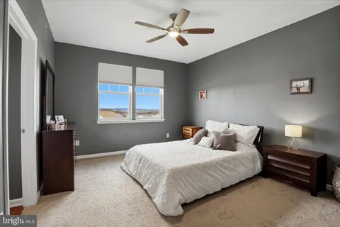 a bedroom with a bed and a ceiling fan