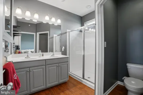 a bathroom with a double vanity sink mirror and toilet