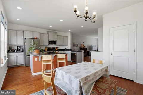 a kitchen with granite countertop wooden floors refrigerator and cabinets