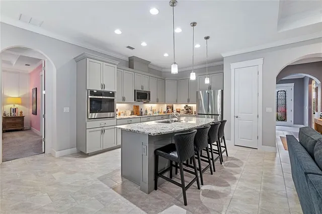 a kitchen with kitchen island granite countertop a center island a sink stainless steel appliances and cabinets