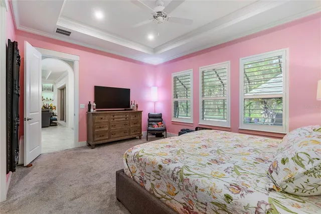 a spacious bedroom with a bed and a television