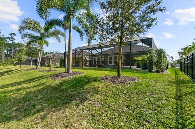 a view of a house with a big yard and palm trees