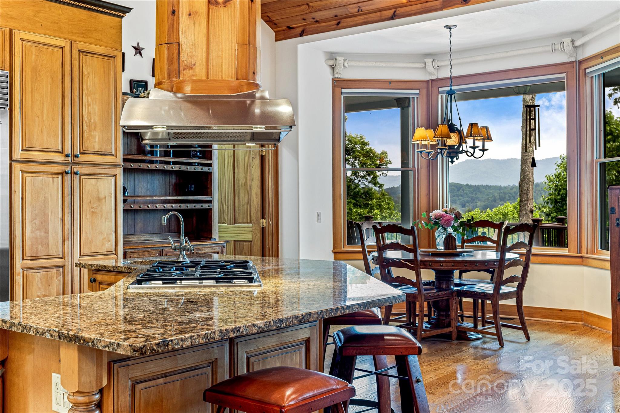 1987 Rabbit Hop Road Spruce Pine, NC 28777 - Photo 29 of 47 a kitchen with stainless steel appliances granite countertop a stove top oven a dining table and chairs with wooden floor