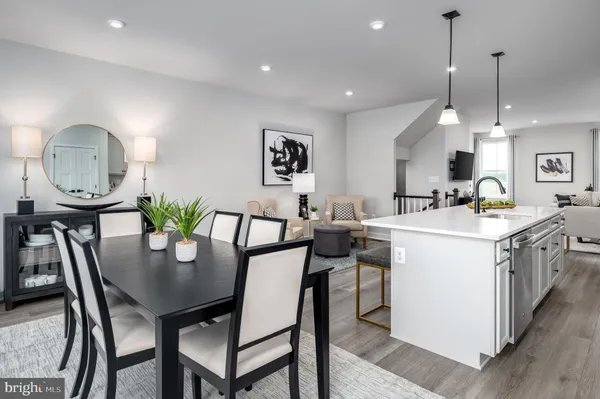a kitchen with a dining table chairs sink and cabinets