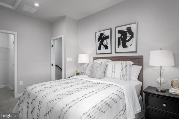 a bedroom with a bed and a lamp on dresser