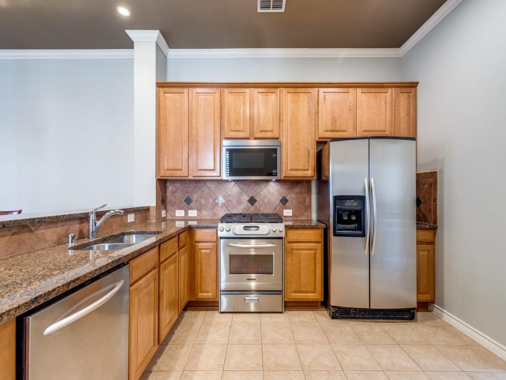 15741 Seabolt Place, Unit 28 Addison, TX 75001 - Photo 11 of 40 a kitchen with stainless steel appliances granite countertop a stove a sink and a refrigerator
