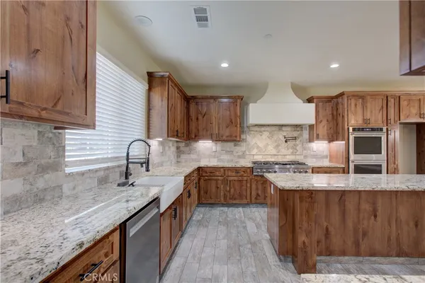 a kitchen with stainless steel appliances granite countertop a sink stove and cabinets