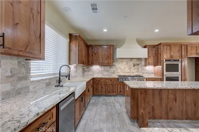 a kitchen with stainless steel appliances granite countertop a sink stove and cabinets