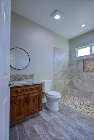 a view of bathroom with a toilet a sink and a mirror