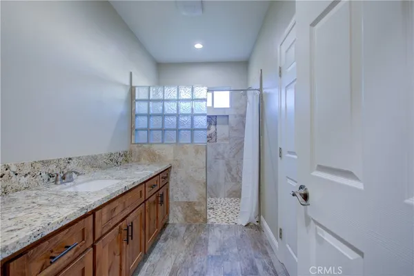 a bathroom with a granite countertop sink a toilet and shower