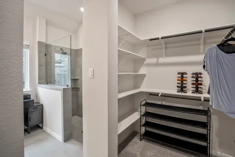 a view of walk in closet with clothes and shoes