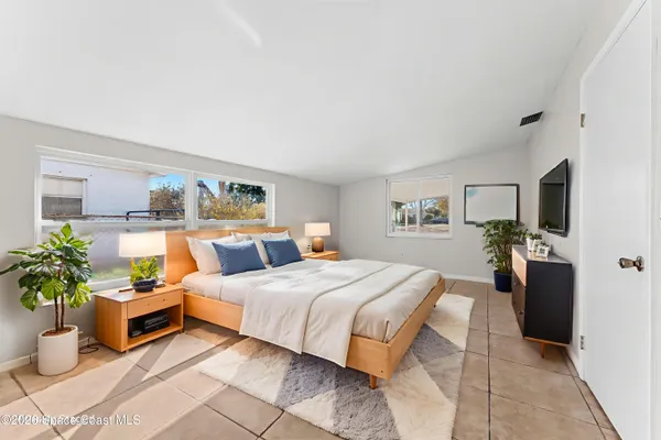 a bedroom with a large bed and potted plant