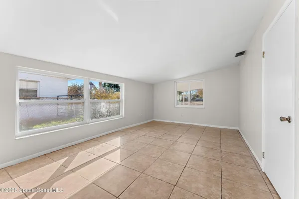 an empty room with entrance and windows