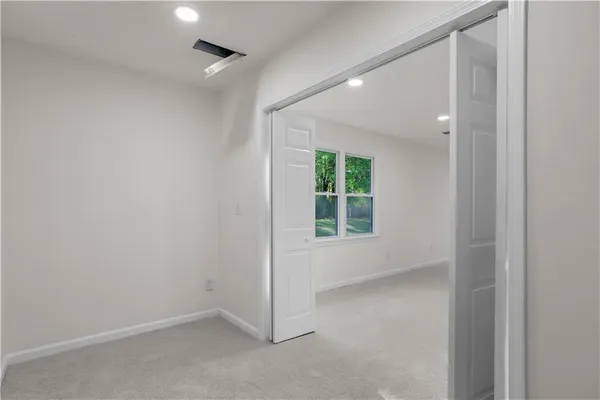 an empty room with windows and closet