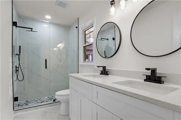 a bathroom with a sink a toilet and a mirror