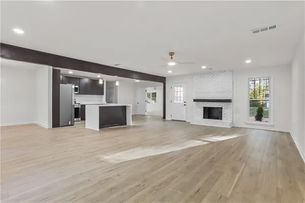 a view of empty room with a kitchen and a fireplace