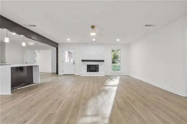 an empty room with wooden floor and fireplace