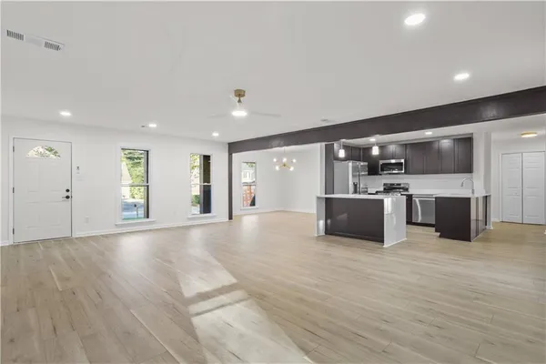a large white kitchen with stainless steel appliances kitchen island a cabinets and wooden floor