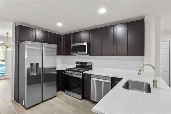 a kitchen with granite countertop a refrigerator and a sink