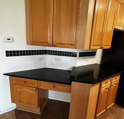 a kitchen with granite countertop cabinets and black appliances