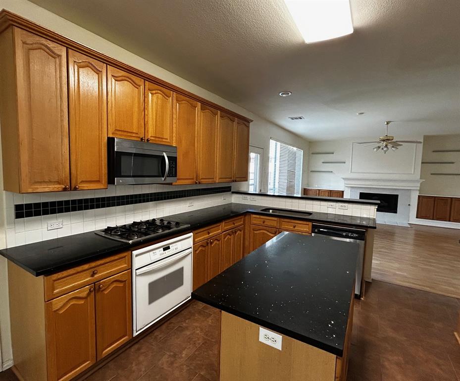 4341 Brinker Court Plano, TX 75024 - Photo 9 of 21 a kitchen with stainless steel appliances granite countertop a stove a sink and a microwave